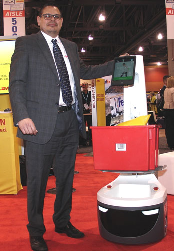 Adrian Kumar, vice president of solutions design for North America for DHL Supply Chain, sidles up to a LocusBot at the Retail Industry Leaders Association’s gathering in Phoenix. (Photo by Paul Scott Abbott, AJOT)