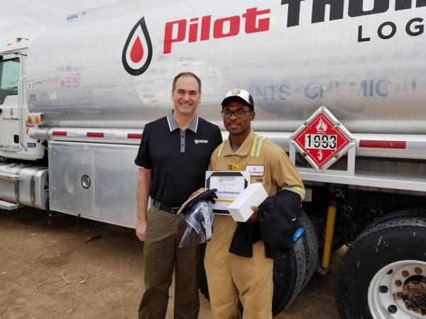 Nathan Stahlman (L) presents Kalayo Bamigboye with a variety of gifts 