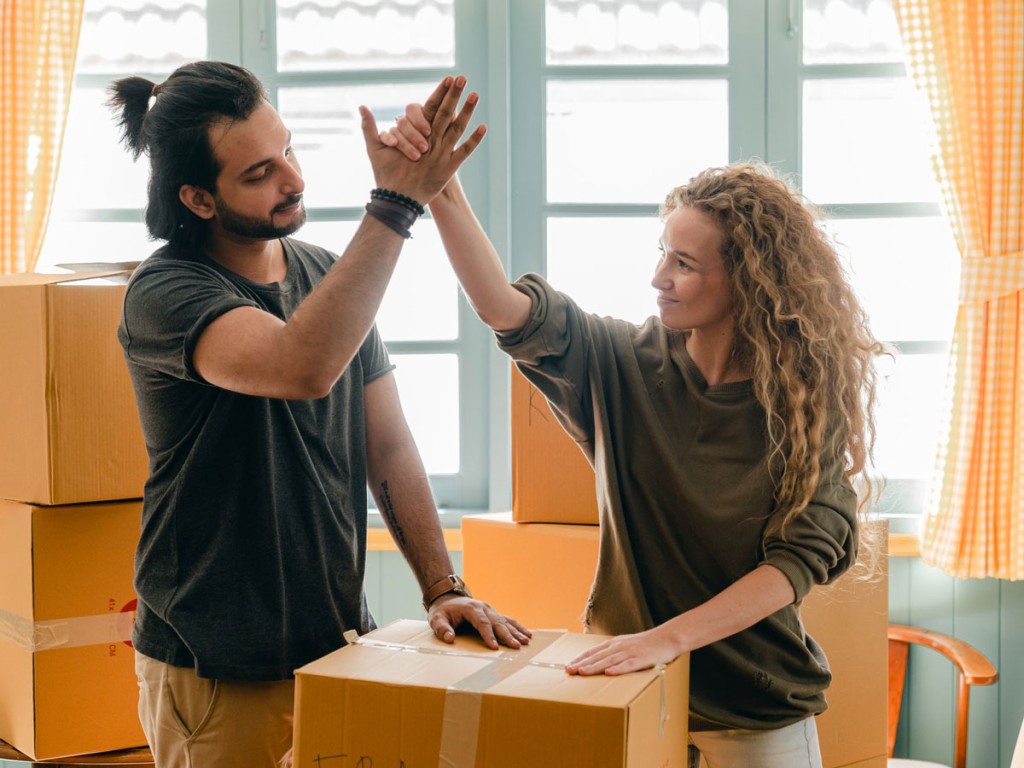 A couple giving a high five after moving into a home