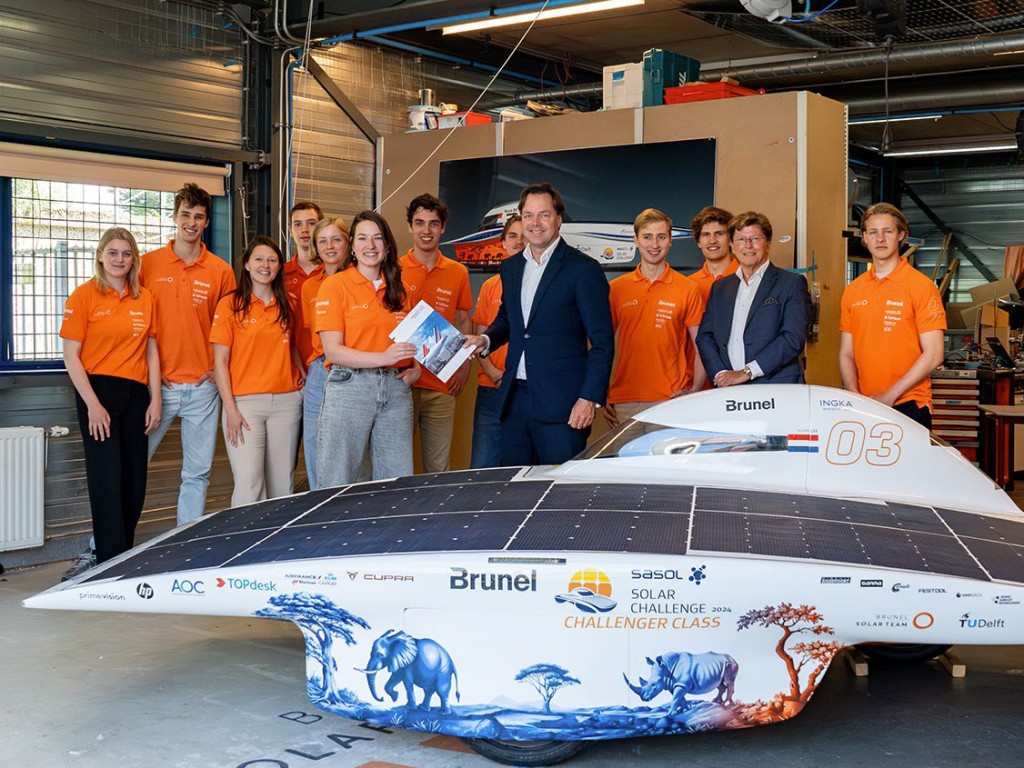 A delegation from AFKLMP Cargo surrounded by the Brunel Solar Team in their pit box in Delft.