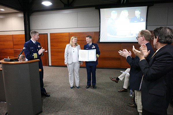 The Captain of the Port, USCG Captain, Tony Hahn, presents Environmental Planning and Compliance Director, Sarah Garza, a Public Service Commendation. 