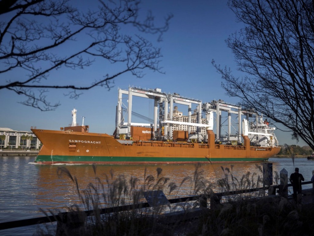 Five new RTG cranes sail past historic River Street in Savannah on board the vessel Sampogracht on the way to being delivered to the Georgia Ports Authority's Garden City Terminal, Friday, Dec. 3, 2021. (GPA Photo/Stephen B. Morton)