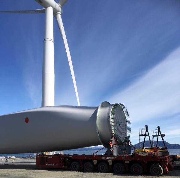 Transporting a blade. One of the completed turbines in the background.