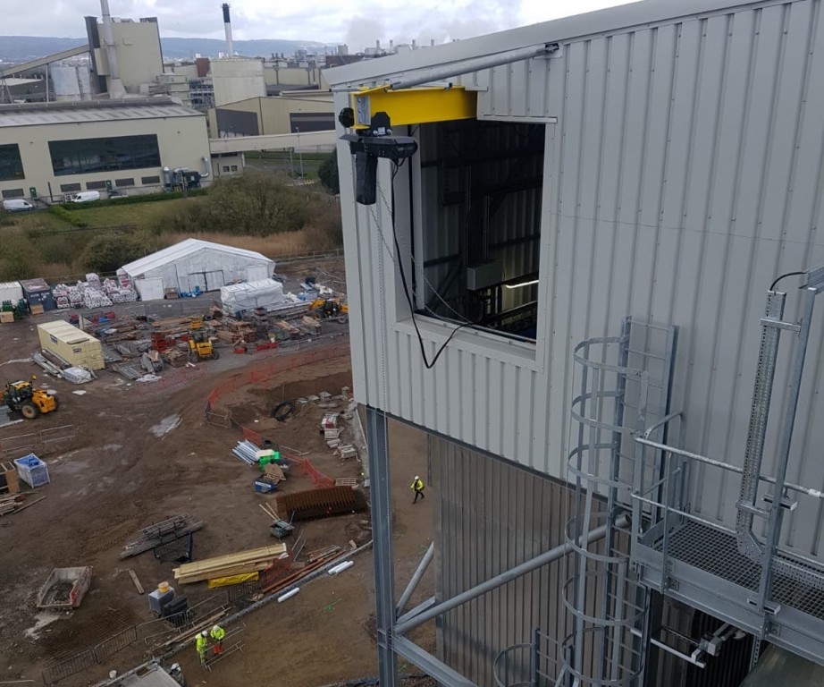 A cantilevered beam protrudes from the top of the filter bag house.